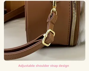 Close-up of adjustable shoulder strap with gold buckle on a brown cartoon crossbody bag