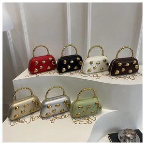 Detail van kleurrijke box-tassen met metalen spiraalgrepen en gouden studs
