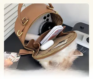 Top view of brown cylinder bag interior showing ample storage for phone and makeup