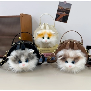 Detailed view of three round cat-themed handbags in black, cream and brown faux fur