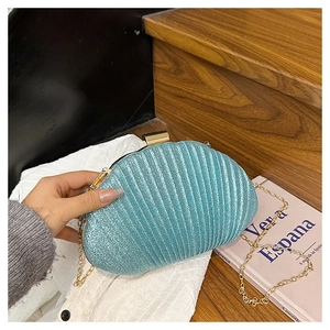 Gros plan sur le sac de soirée bleu ciel en forme de coquille avec sa chaîne dorée chic