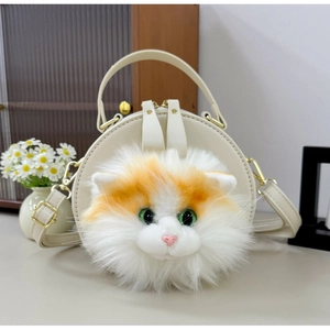 Detail of round cream handbag featuring a plush orange cat face and gold hardware