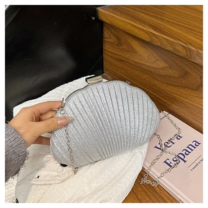 Détail de la pochette argentée en forme de coquillage avec paillettes et bandoulière