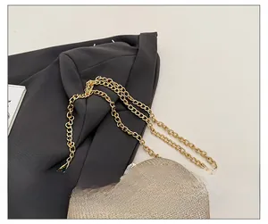 Detailed close-up of the exquisite gold chain strap on a shimmering glitter handbag