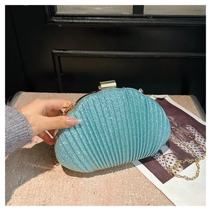 Gros plan sur la pochette de soirée en forme de coquillage bleu clair à paillettes