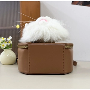 Detailed view of the cat-shaped plush top and brown leather cylindrical crossbody bag