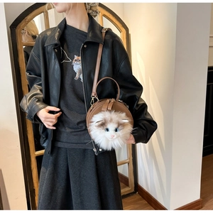 Detailed view of brown leather round bag with 3D realistic plush cat face decoration