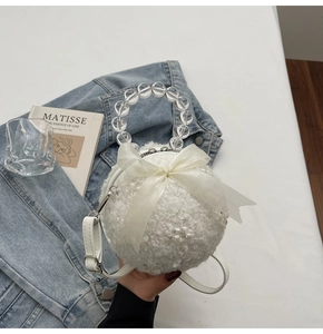 Detailed view of spherical plush bag with organza bow and transparent bead handle