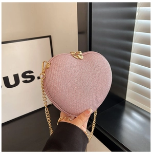 Detailed macro view of sparkling pink glitter fabric and heart-shaped metal zipper pullers