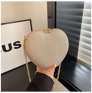 Detail of champagne gold heart shaped glitter handbag with metal chain and twin zippers
