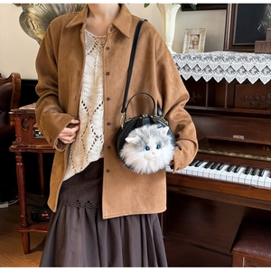 Detail of round plush cat head crossbody bag worn by model in vintage style outfit