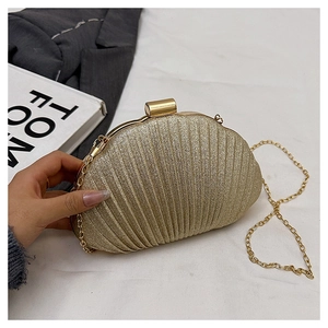 Détail de la pochette de soirée dorée en forme de coquillage avec revêtement pailleté