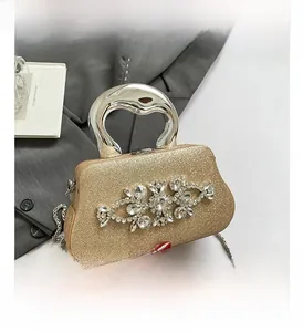 Detail of glitter evening clutch featuring crystal floral patterns and metal handle