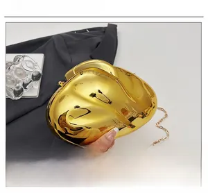 Detail of a gold mirrored geometric evening bag with a delicate chain strap