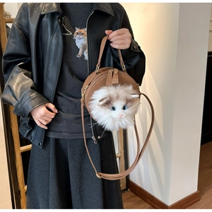 Close-up of a brown round crossbody bag with a 3D plush cat head and soft faux fur detail