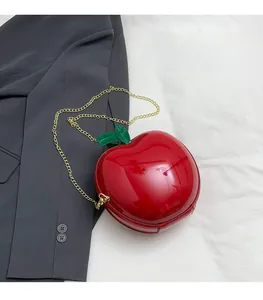 Detailed view of the red apple shaped hard shell crossbody bag with golden chain