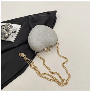 Macro shot of silver glitter heart bag with gold zippers and metal chain strap details