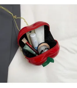 Macro view of interior storage for a creative red apple crossbody bag with cosmetics