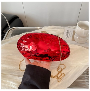 Dettaglio borsa da sera in acrilico specchio rosso con trama ondulata e catena