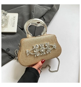 Detail of glitter clutch with crystal flower decor and polished silver metal handle