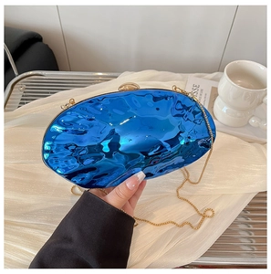 Dettaglio della borsa da sera blu a specchio con texture ondulata e catena dorata
