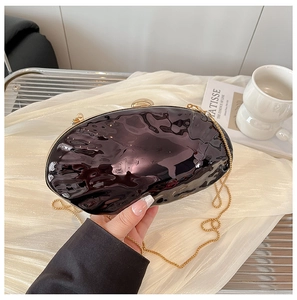 Dettaglio borsa a mano in acrilico viola ondulato con chiusura a sfera dorata