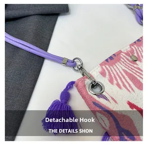 Détail du crochet amovible sur un sac cabas avec pompon violet et cordon tressé