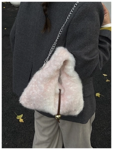 Detail of pink and white plush bucket bag with silver chain and gold ball charm