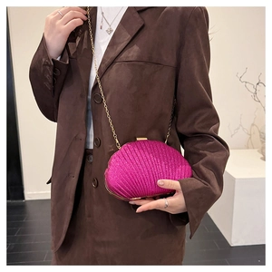 Détail du sac de soirée plissé en forme de coquillage rose avec bandoulière dorée
