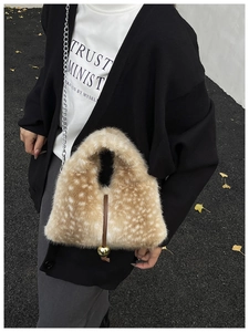 Detail of faux fur deer pattern handbag with brown leather tie and golden ball charm