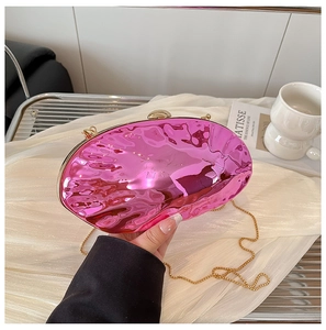 Dettaglio della pochette in acrilico rosa a conchiglia con catena dorata e onde
