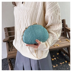 Détail de la pochette de soirée bleu menthe en forme de coquillage avec chaîne dorée