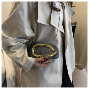 Detail of grey velvet clutch with sparkling rhinestones and gold wavy metal accent