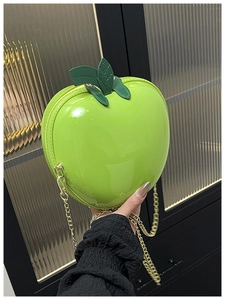 Vue détaillée du mini sac pomme verte brillante avec coque rigide et chaîne dorée