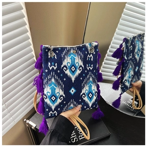 Détail du sac ethnique avec motifs géométriques et pompon à franges violettes