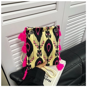 Vue détaillée du sac cabas ethnique avec motifs géométriques et pompons rose vif