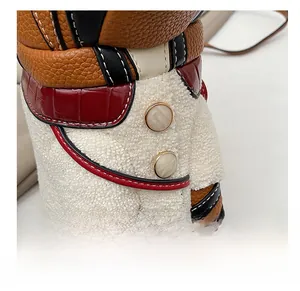 Detail of tiger bag featuring brown leather, red faux skin, and soft white fleece texture