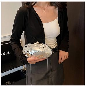 Dettaglio pochette da sera argento con trama a onde metalliche e catena sottile