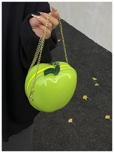 Détail d'un sac à chaîne créatif en forme de pomme vert vif avec détails de feuilles