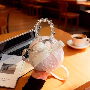 Pink plush ball handbag with beaded handle and white satin bow, crossbody style