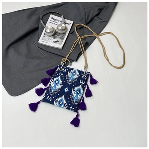 Vue détaillée d'un sac ethnique avec glands violets et accessoires de mode sophistiqués