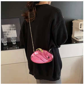 Close-up of bright pink metallic acrylic clutch with gold chain and glossy mirror finish