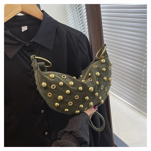 Détail du sac lune en daim vert avec clous dorés et anneaux métalliques