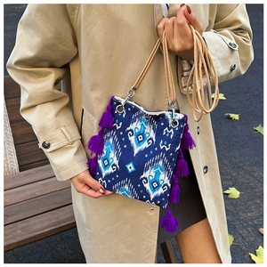 Détail du sac cabas ethnique avec pompons violets et motif géométrique tissé