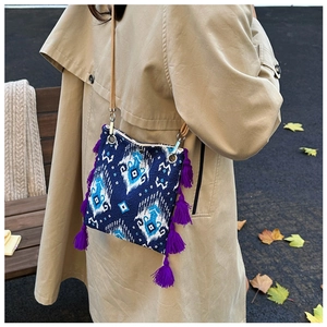 Détail du sac ethnique avec motif ikat bleu et finitions à longues franges violettes