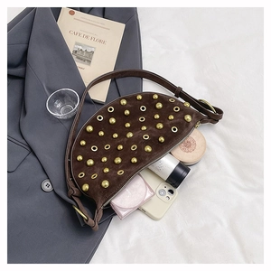 Vue détaillée du sac demi-lune en daim marron avec rivets dorés montrant son espace interne