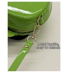 Detail of bright green patent leather apple bag with detachable gold metal clasp