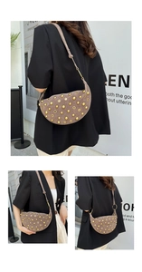 Macro detail of taupe suede hobo bag with golden rivets and metallic ring connector