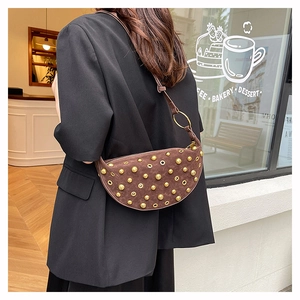 Detail of vintage brown suede crescent bag with gold rivets and metallic eyelets
