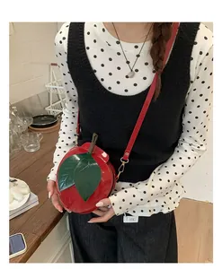 Creative apple-shaped crossbody bag in bright red patent leather with green leaf detail